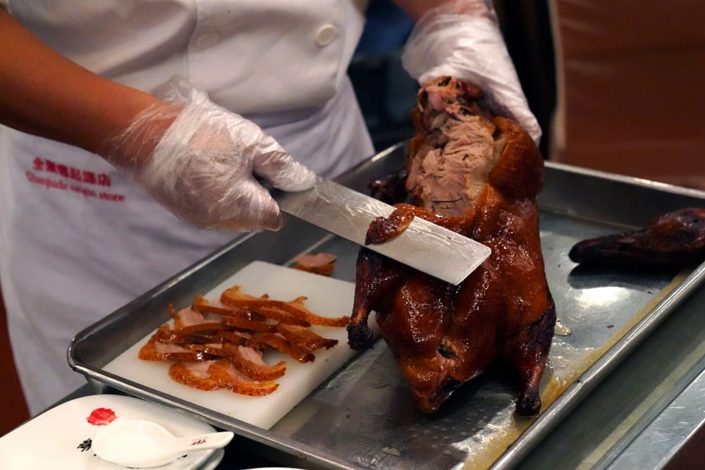 A chef chops duck meat slices for customers at the Quanjude Peking roast duck restaurant in Beijing, China August 18, 2020. — Reuters pic