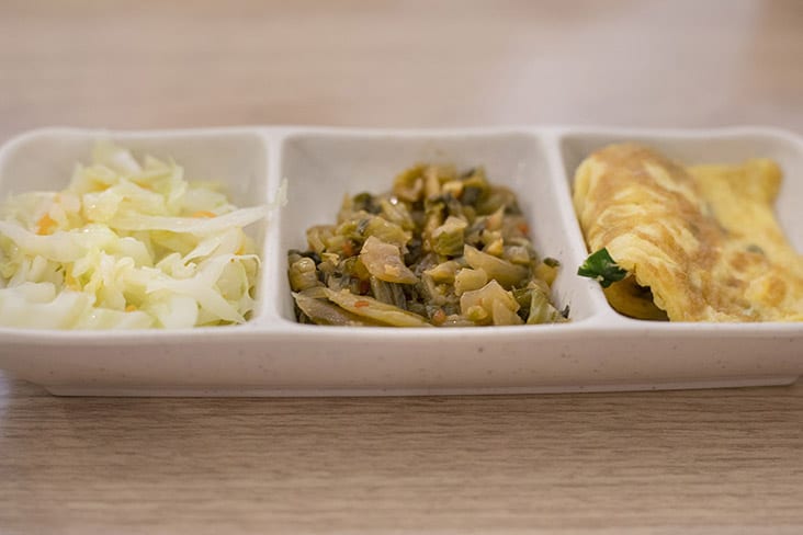 Bento sides may vary; one set featured omelette, shredded cabbage and pickled vegetables.