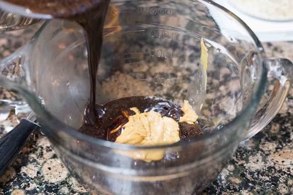 Peanut butter and chocolate in a glass bowl for a no bake cookie recipe.