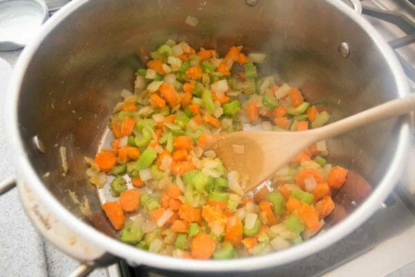 Diced vegetables sauteed and stirred with a wooden spoon to make Chicken and Dumplings.