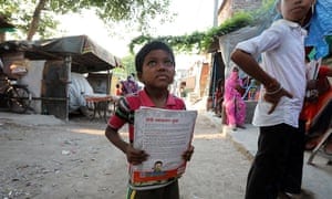 A boy holds a textbook outside his home at the Shahdara drain slum area on the outskirts of New Delhi. The Covid-19 pandemic has disrupted the education of millions of children and increased their vulnerability to exploitation.