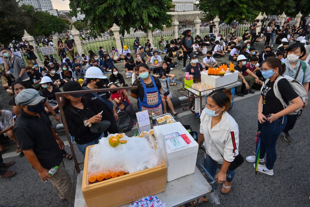 This picture taken October 21, 2020 shows street food vendors selling sandwiches and orange juice setting up stalls during an anti-government rally by pro-democracy protesters in Bangkok. — AFP pic