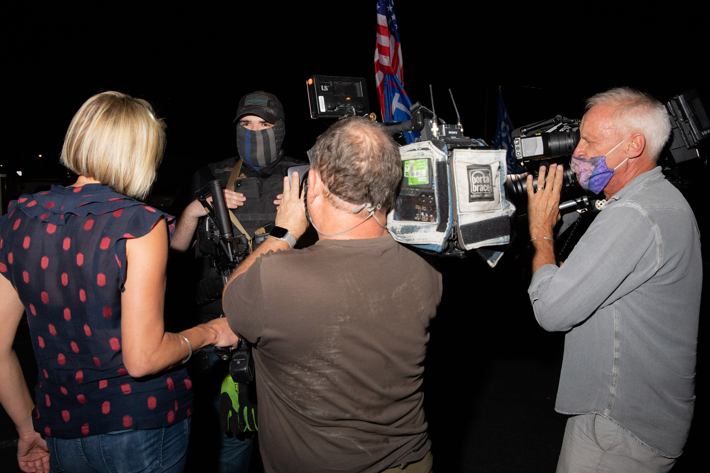 A member of a militia is flanked by cameras at the Maricopa County Elections office in Phoenix, on Nov. 5