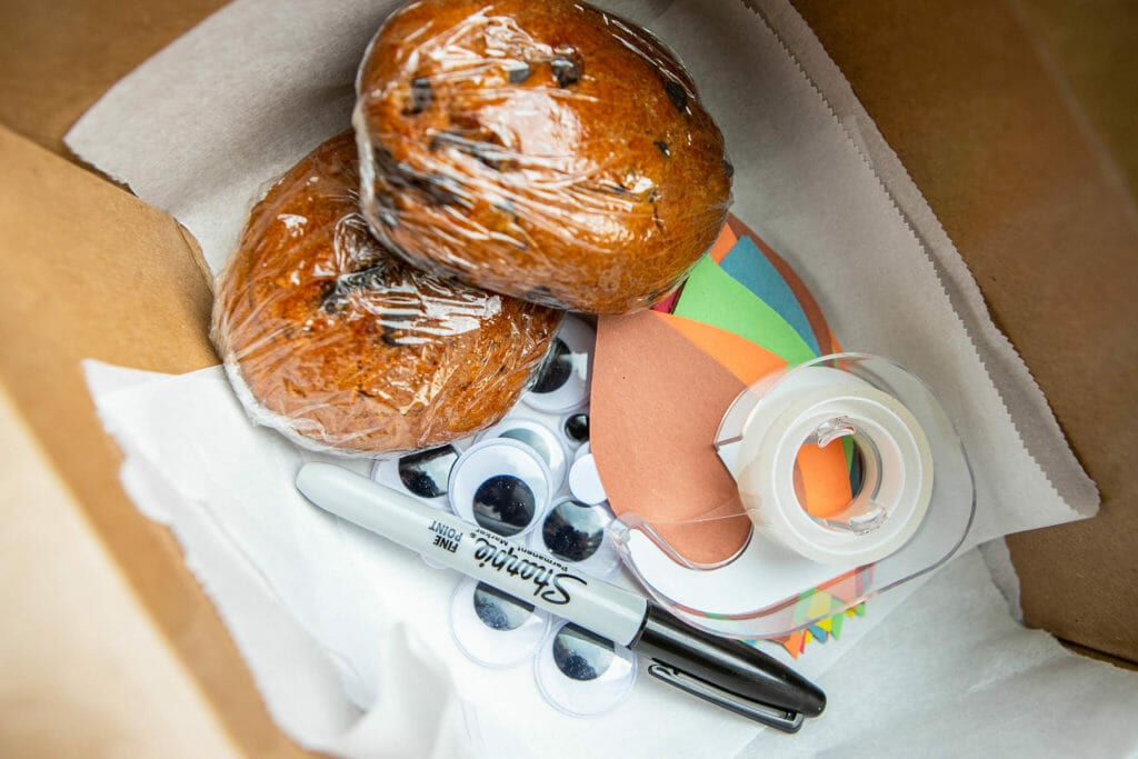 Craft supplies and cookie dough in a cardboard box for Long-distance Thanksgiving ideas.