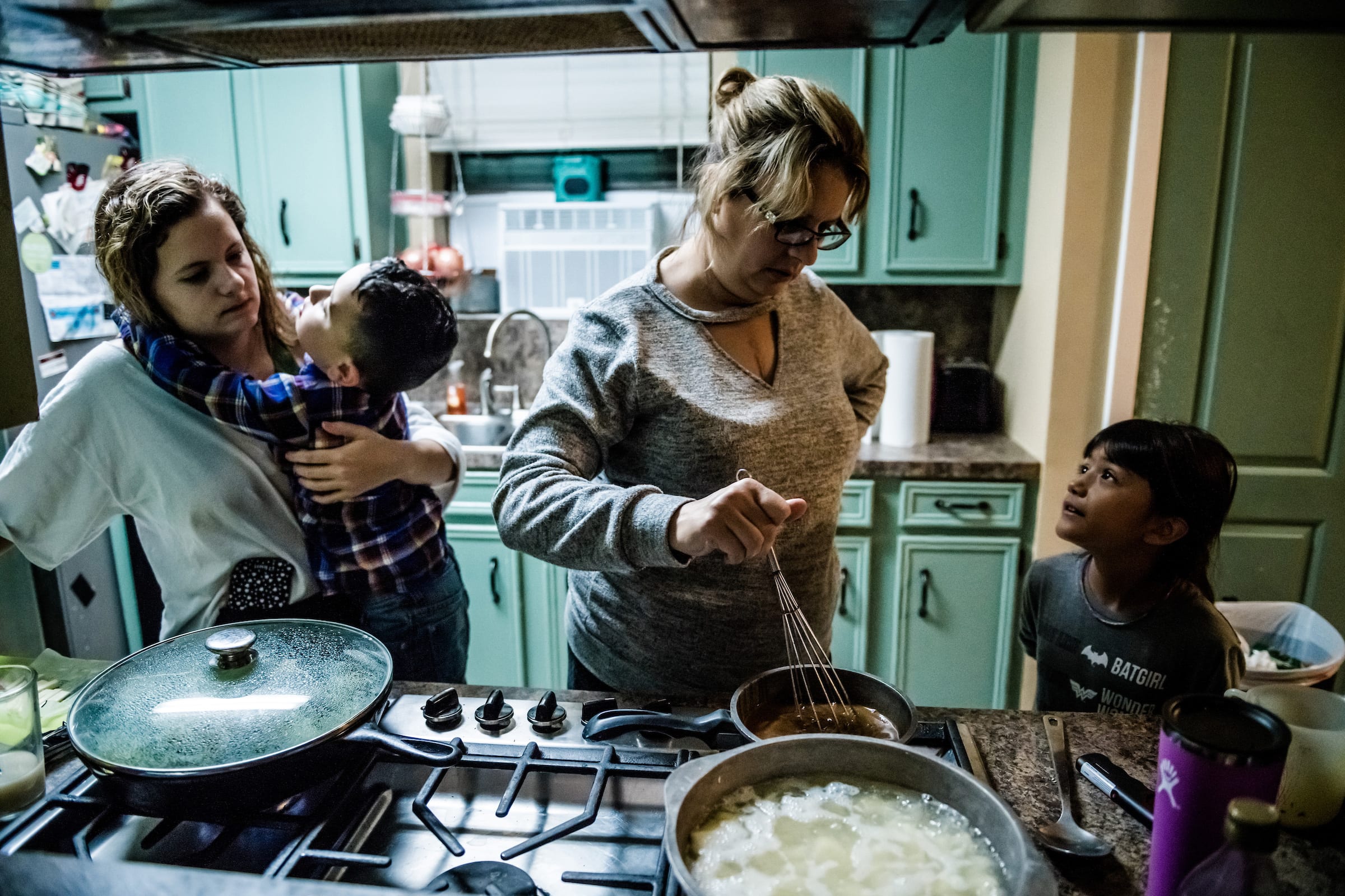 Jessica Higginbotham, second from right, is thankful she was able to cook dinner for her five children on Nov. 17, 2020. She survived heart and kidney transplants in 2019; she and three other members of her family had COVID-19 this year. The health issues, paired with her husband Jeremiah’s losing hours at work, cost the Baytown, Texas, family most of their life savings.