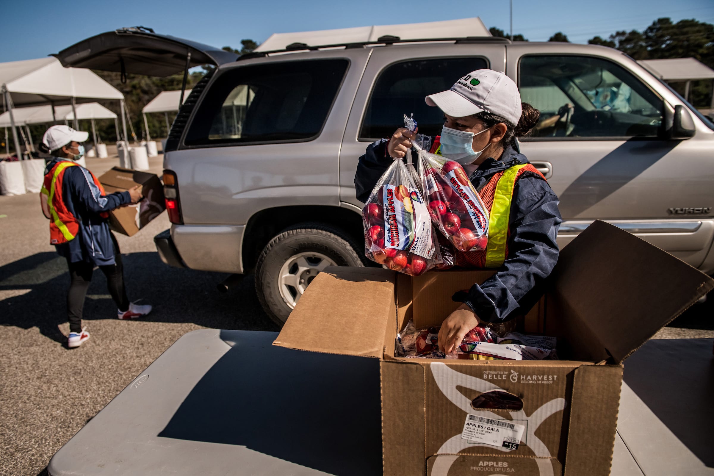 Boxes of food are loaded into cars at the food distribution site run by the Houston Food Bank.