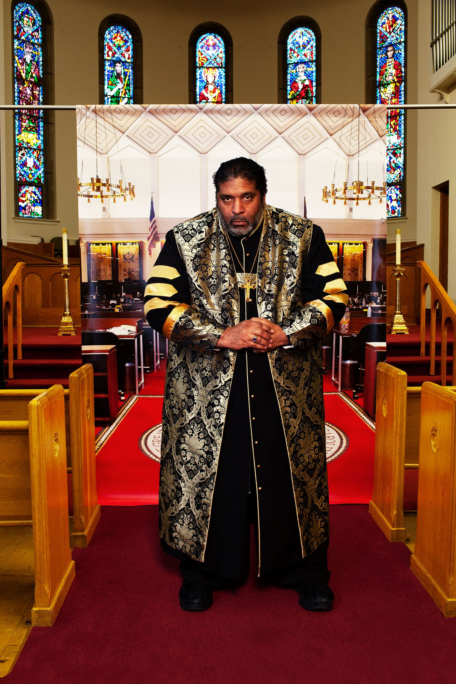 The Rev. William J. Barber II at Pullen Memorial Baptist Church in Raleigh, N.C., on Jan. 27, before a backdrop showing the North Carolina house of representatives chamber where he was arrested in 2011.  The Equalizers,  March 2 issue.