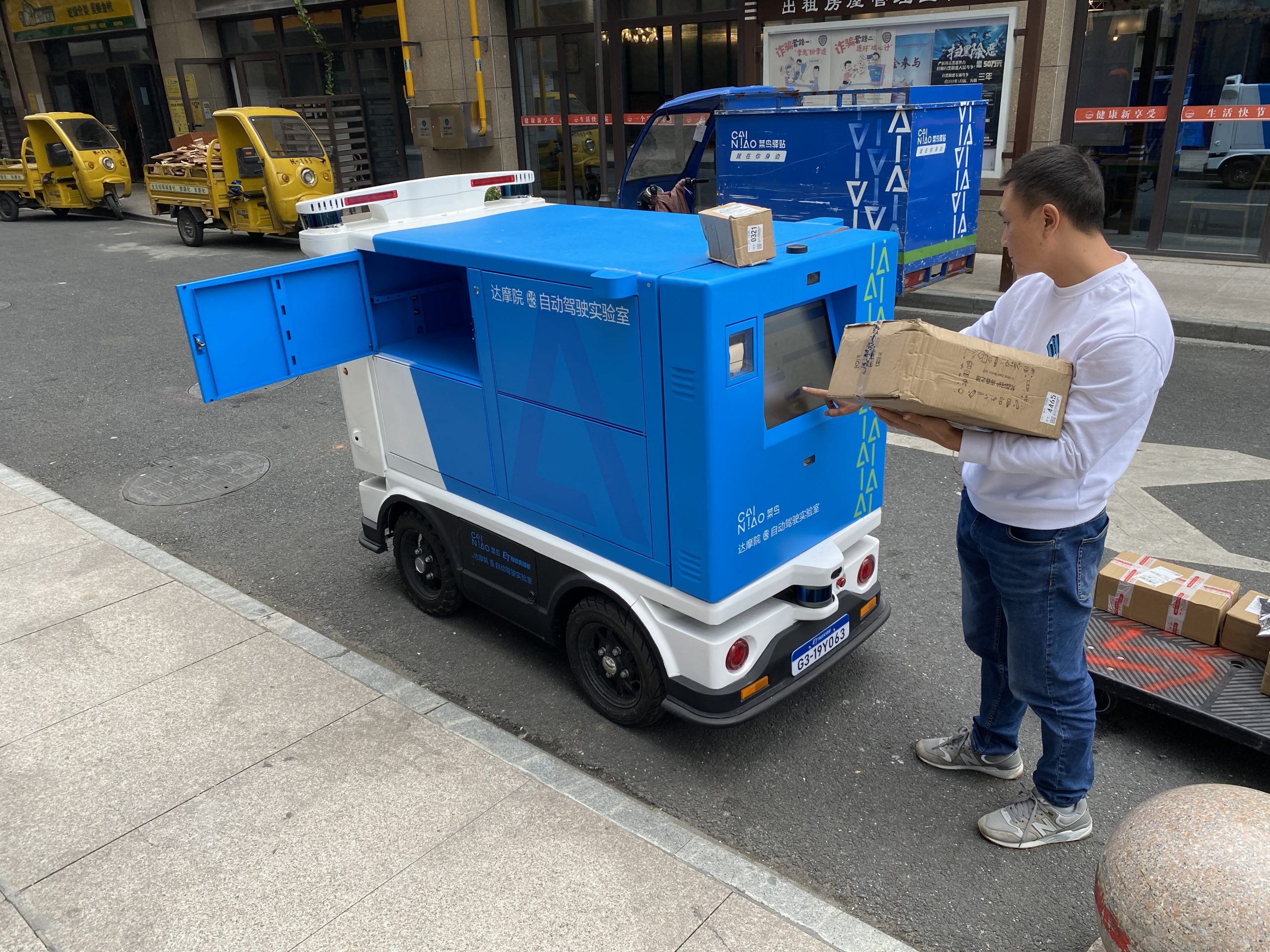 Cainiao engineer Long Fei loads packages onto the firm’s Xiao G automated delivery vehicle in Hangzhou, China on Oct. 19, 2020.