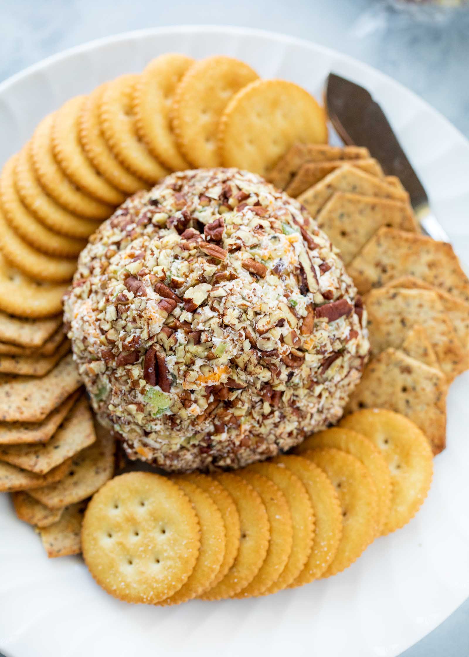 Classic cheeseball in the center of a platter and surrounded by crackers.