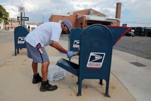 FILE PHOTO: FILE PHOTO: A United States Postal Service (USPS) worker handles the mail in a drop-off box behind a post office in Oak Park, Michigan, U.S. August 17, 2020. REUTERS/Rebecca Cook/File Photo/File Photo