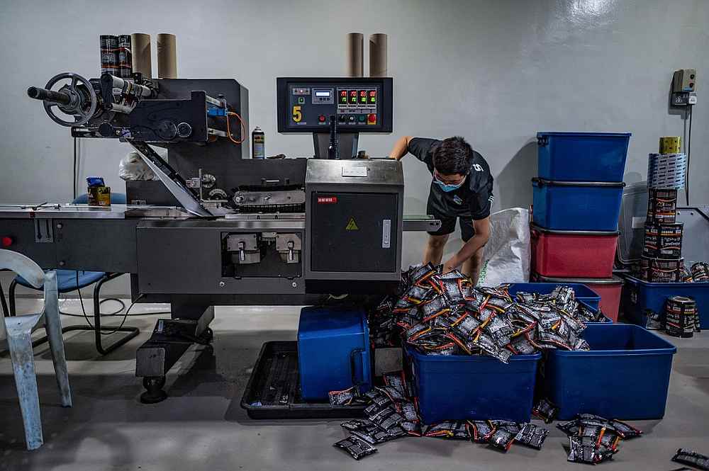 A worker sorting coffee packets at the Antong Coffee Factory in Taiping, Perak September 29, 2020. — AFP pic