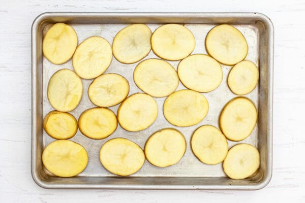 Yukon gold potatoes sliced into rounds and set on a baking sheet.