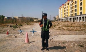A Chinese police officer takes his position by the road near what is officially called a vocational education centre in Yining in Xinjiang