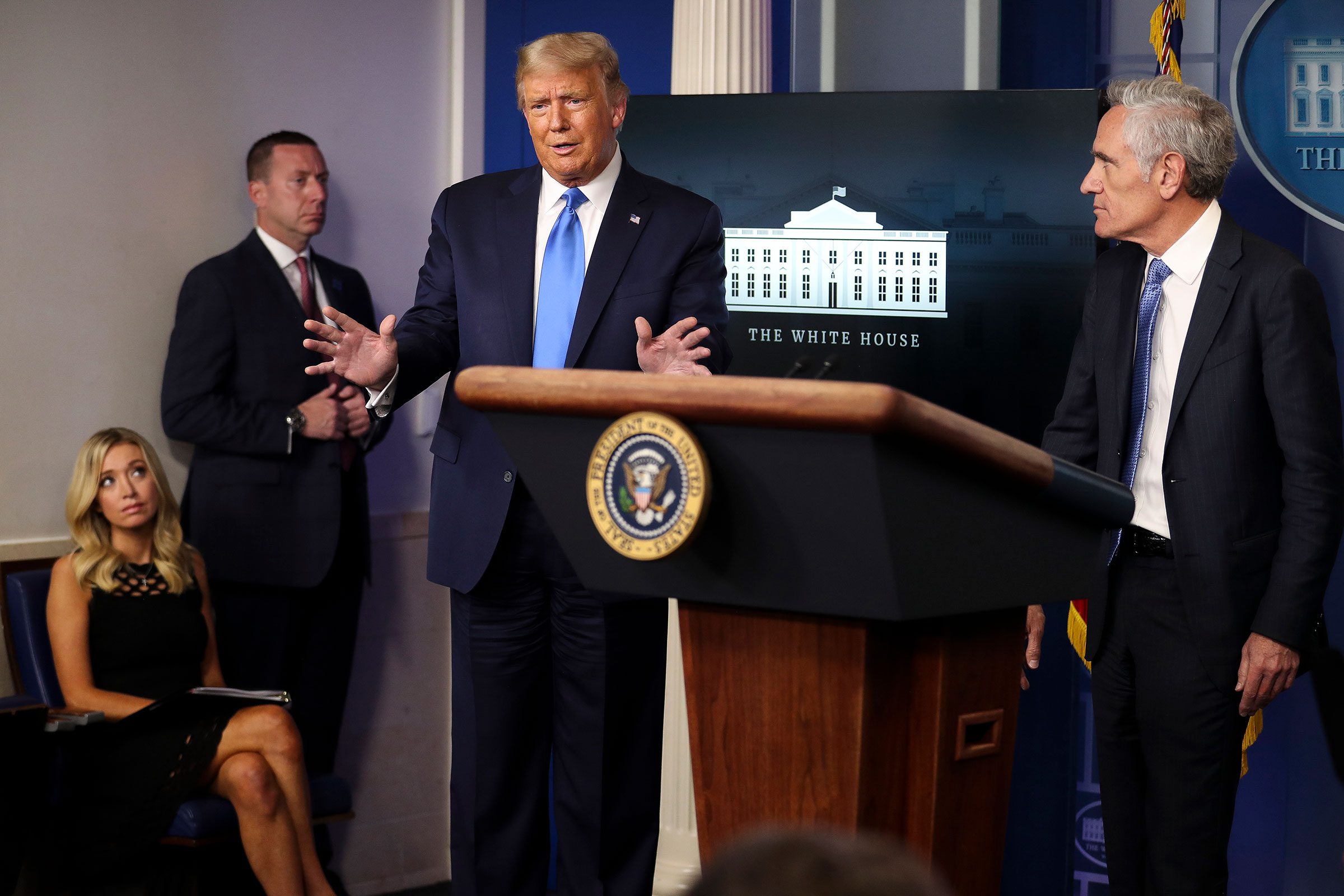 President Donald Trump speaks as Dr. Scott Atlas, a White House adviser on the coronavirus, right, and White House Press Secretary Kayleigh McEnany, far left, listen during a press briefing at the White House in Washington, on Wednesday, Sept. 23, 2020. (Oliver Contreras/The New York Times)