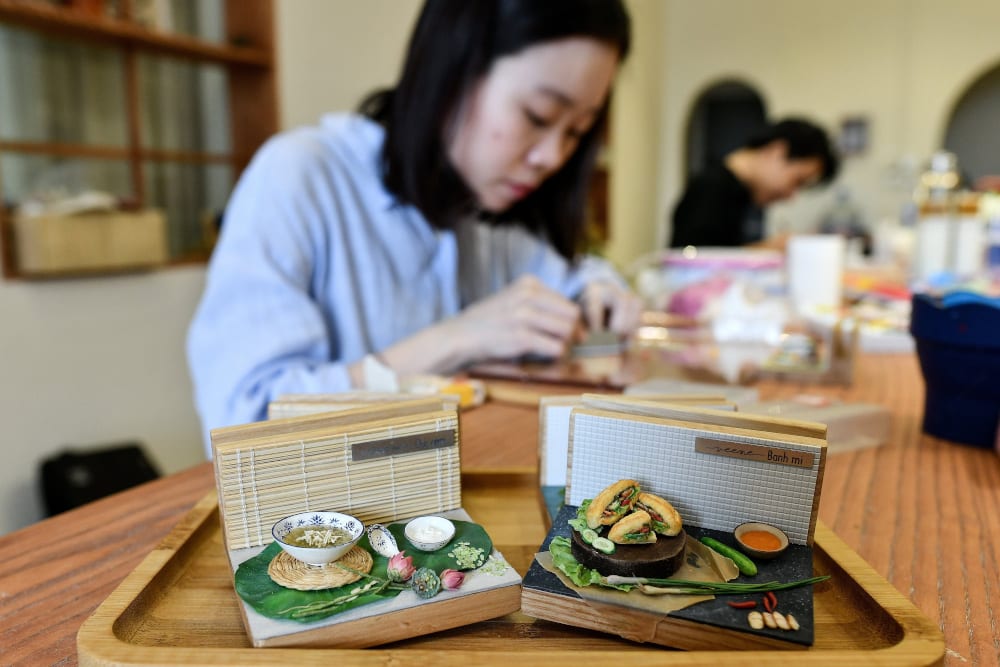 This photograph taken on August 18, 2020 shows miniature artist Nguyen Thi Ha An working at her studio in Hanoi. — AFP pic