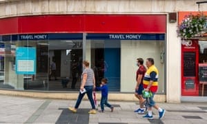 People walk past a closed Tui travel shop in Slough on Saturday.